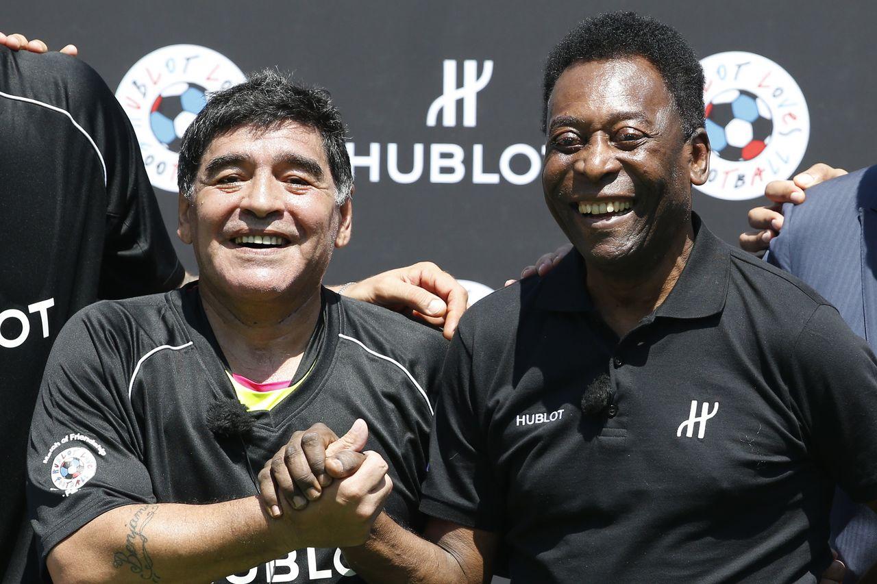Former Argentinian football international Diego Maradona (L) and former Brazilian footballer Pele pose after a football match organised by Swiss luxury watchmaker Hublot at the Jardin du Palais Royal in Paris on June 9, 2016, on the eve of the Euro 2016 European football championships. (Photo by PATRICK KOVARIK / AFP)