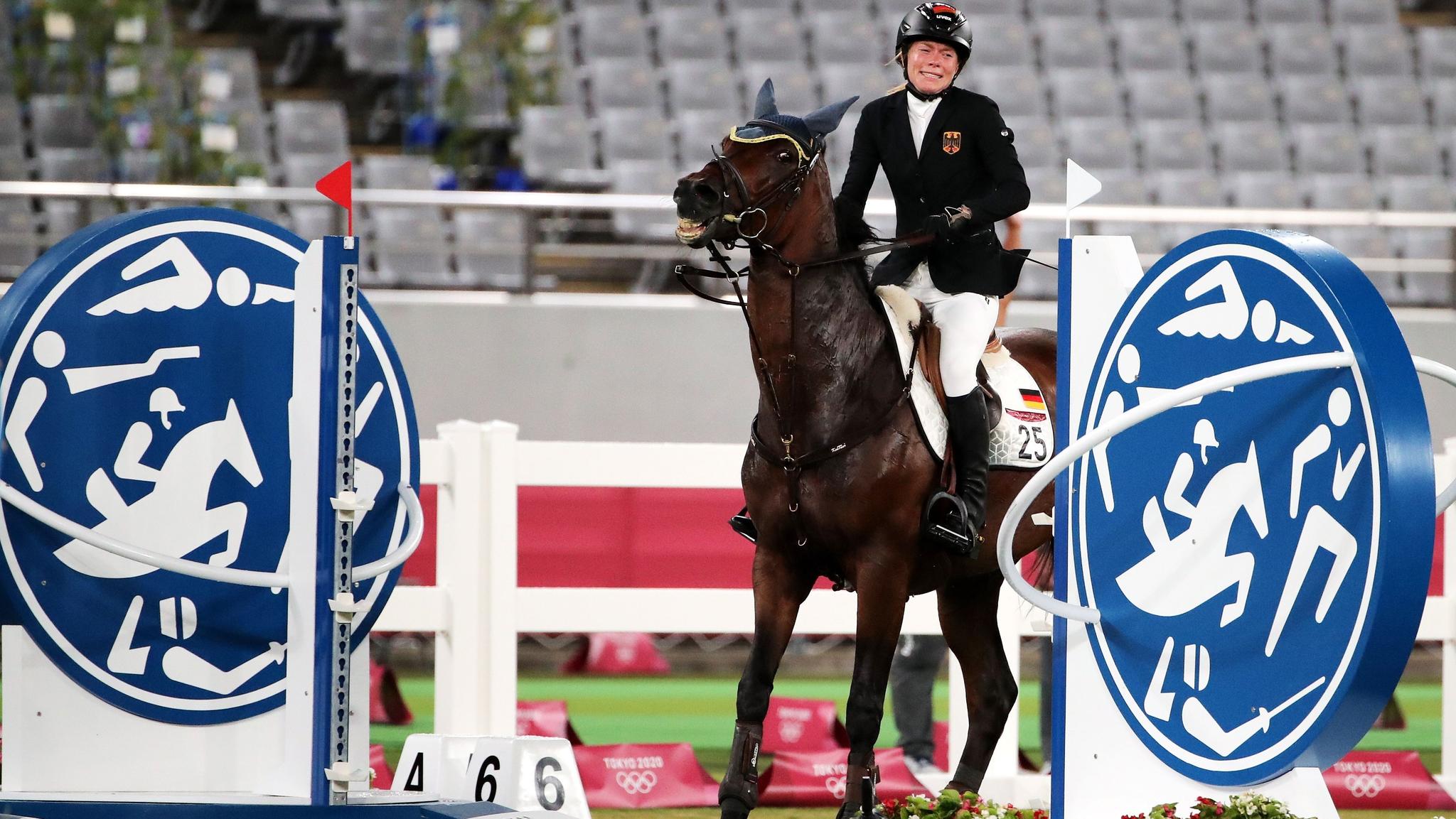 A alemã Annika Schleu chora após o cavalo Saint Boy destruir um obstáculo e suas chances de medalha no pentatlo moderno de Tóquio.