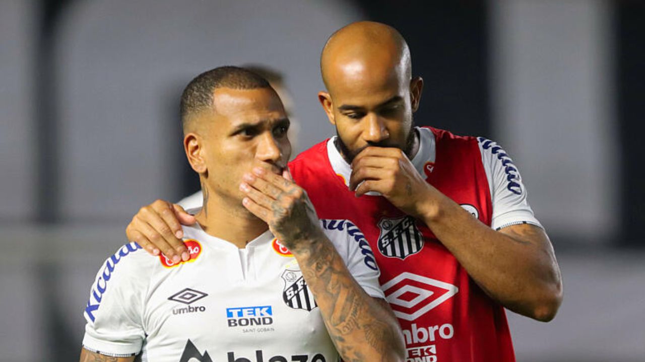 Patrick, de vermelho, ao lado de Otero no Santos: meia está perto do Furacão