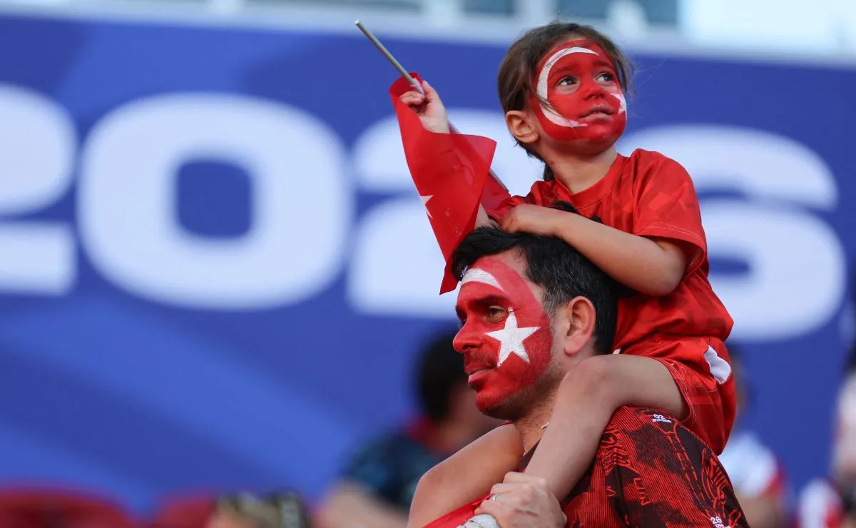 Torcedores da Turquia aparecem nas arquibancadas durante partida da Copa do Mundo de 2026, exibindo bandeiras e demonstrando apoio à seleção.