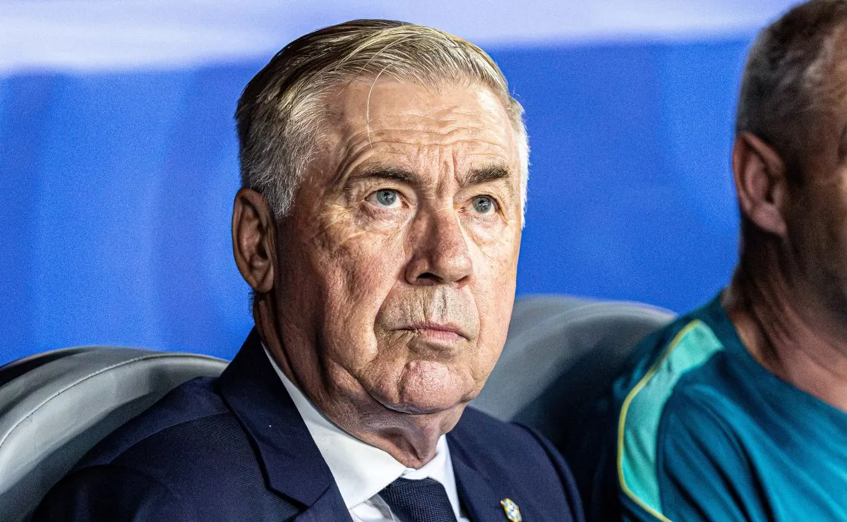 Carlo Ancelotti observa a partida sentado no banco de reservas durante jogo da Seleção Brasileira.